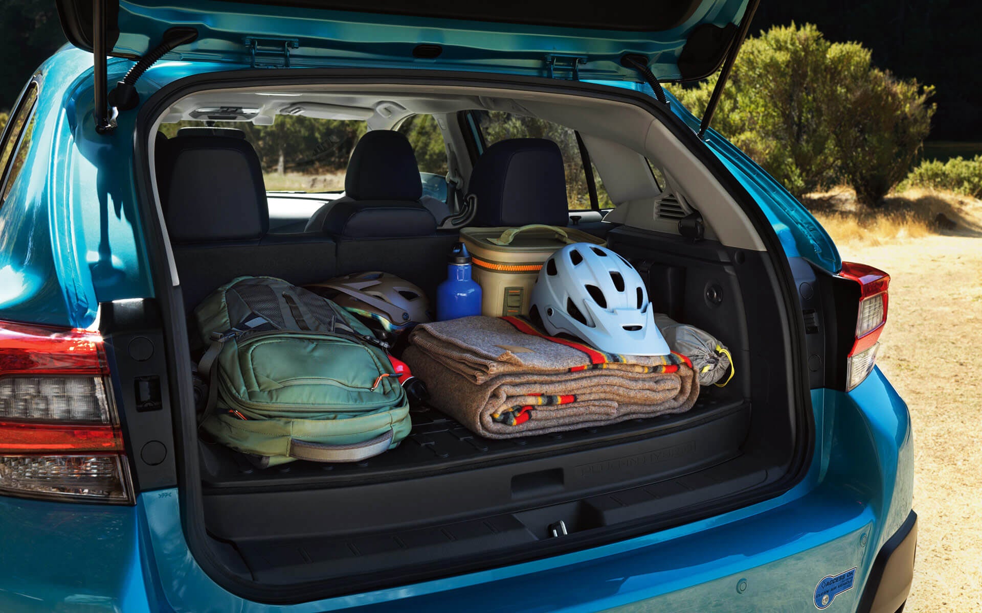 A backpack, blanket, and bike helmet in the rear cargo area of a Crosstrek Hybrid | Subaru World of Hackettstown in Hackettstown NJ