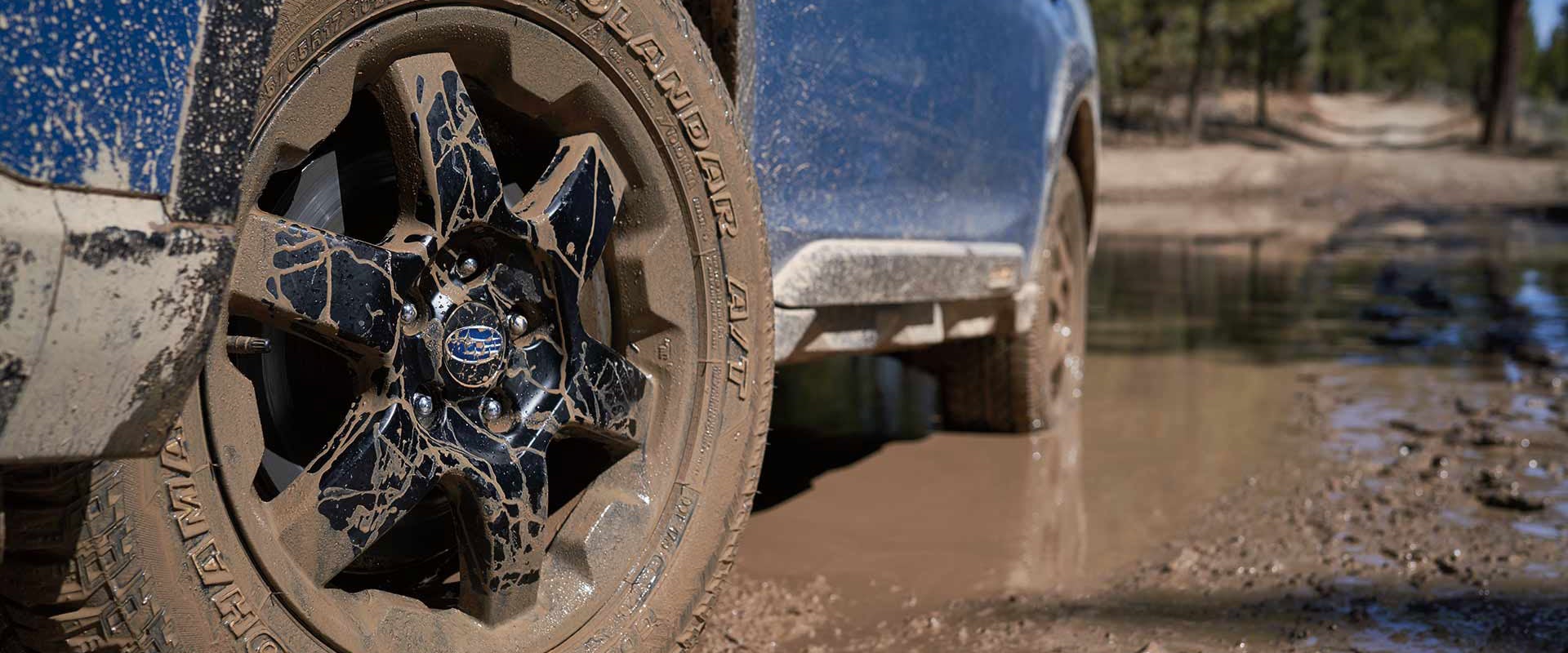 Close-up of muddy Subaru off-road wheels on Forester Wilderness